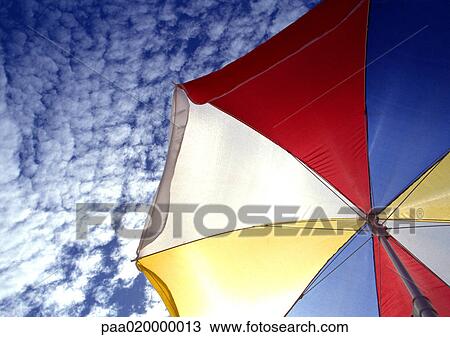 Multi-colored parasol, blue sky with clouds in background, low angle view View Large Photo Image Stock Image - Multi-colored parasol, blue sky with clouds in background, low angle view. Fotosearch