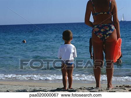 Stock Photo - People standing on beach. Fotosearch