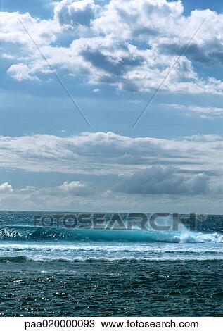 Wave crashing in ocean under blue sky with clouds View Large Photo Image Stock Image - Wave crashing in ocean under blue sky with clouds. Fotosearch