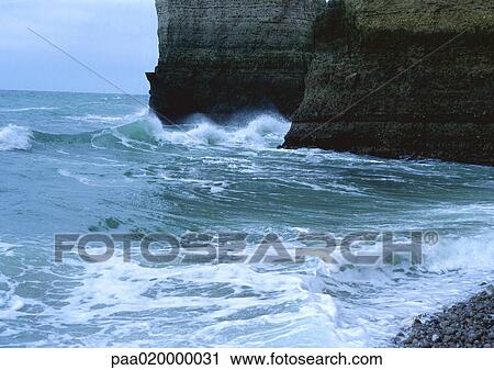 Stock Image - Waves crashing against cliffs. Fotosearch