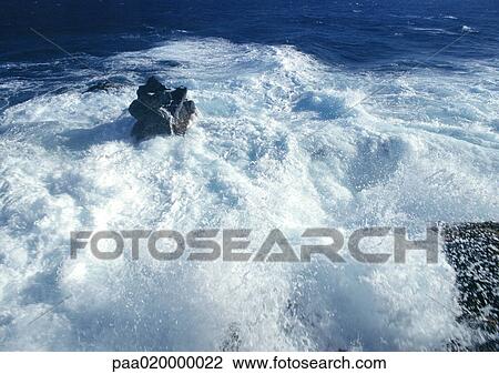 Waves crashing around rock View Large Photo Image Stock Image - Waves crashing around rock. Fotosearch