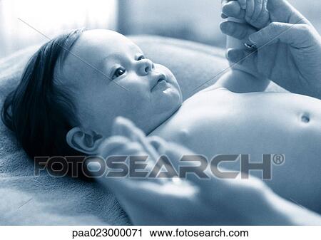 Adult playing with baby lying on table, black and white. View Large Photo Image Stock Image - Adult playing with baby lying on table, black and white.. Fotosearch