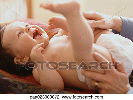 Adult playing with baby lying on table. View Large Photo Image Stock Image - Adult playing with baby lying on table.. Fotosearch