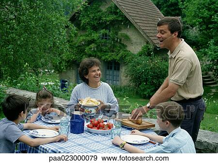 Family eating together outside in the country. View Large Photo Image Stock Photo - Family eating together outside in the country.. Fotosearch