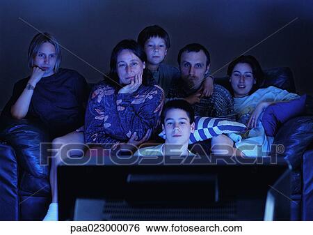 Family watching television together in the dark. View Large Photo Image Stock Photograph - Family watching television together in the dark.. Fotosearch