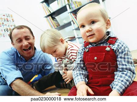 Father sitting on floor with young sons inside. View Large Photo Image Stock Photo - Father sitting on floor with young sons inside.. Fotosearch