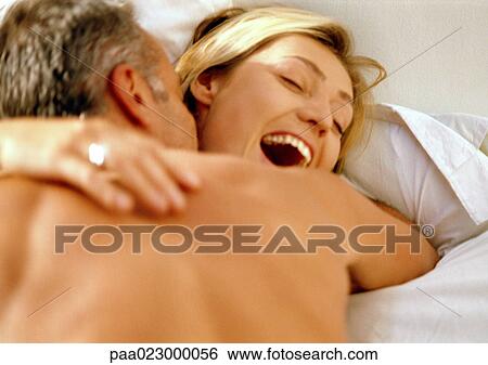 Man embracing laughing woman in bed. View Large Photo Image Stock Photograph - Man embracing laughing woman in bed.. Fotosearch