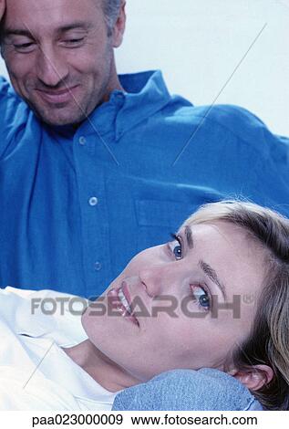 Man looking at woman lying on his leg. View Large Photo Image Stock Photo - Man looking at woman lying on his leg.. Fotosearch