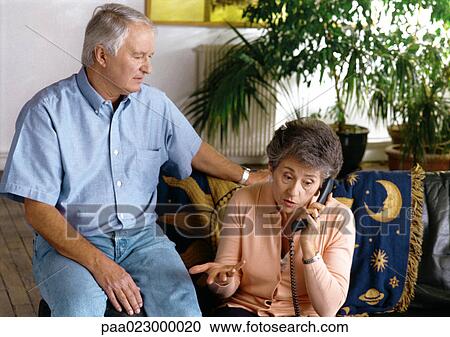 Man sitting next to woman on phone inside. View Large Photo Image Stock Image - Man sitting next to woman on phone inside.. Fotosearch
