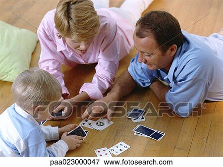 Parents playing cards with child, on floor, high angle view View Large Photo Image Stock Photo - Parents playing cards with child, on floor, high angle view. Fotosearch