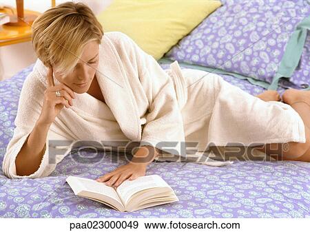 Woman in bathrobe reading on bed. View Large Photo Image Stock Photo - Woman in bathrobe reading on bed.. Fotosearch