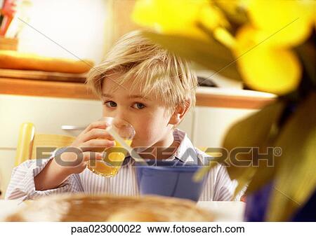 Young boy drinking juice at table. View Large Photo Image Stock Image - Young boy drinking juice at table.. Fotosearch