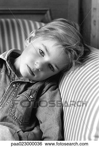Young boy leaning head on chair arm, black and white portrait. View Large Photo Image Stock Photograph - Young boy leaning head on chair arm, black and white portrait.. Fotosearch