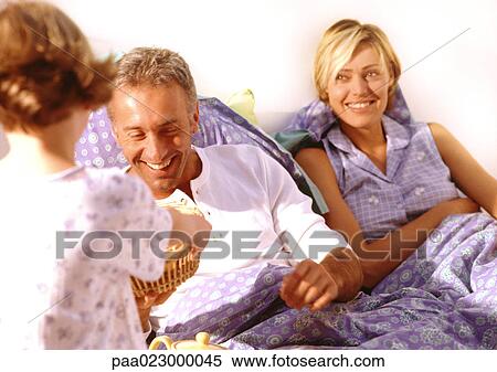 Young child bringing basket to parents in bed. View Large Photo Image Stock Photography - Young child bringing basket to parents in bed.. Fotosearch
