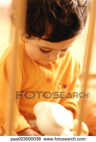 Young child looking at stuffed animal, warm toned, blurry. View Large Photo Image Stock Photo - Young child looking at stuffed animal, warm toned, blurry.. Fotosearch