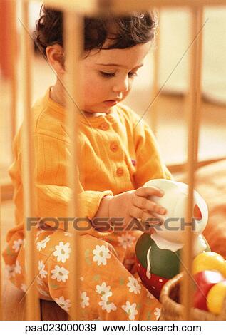 Stock Photo - Young child looking at stuffed toy, warm toned.. Fotosearch
