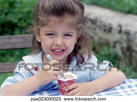 Young girl eating yogurt outside. View Large Photo Image Stock Photography - Young girl eating yogurt outside.. Fotosearch