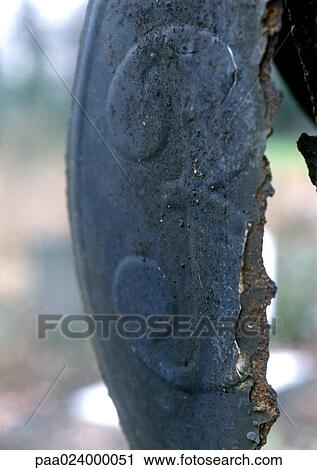 Stock Image - 3 text embossed on broken metal surface. Fotosearch