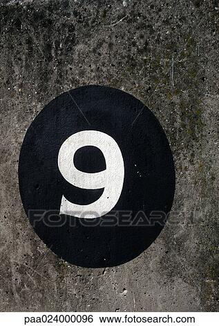 Stock Photograph - 9 text painted on black circle on rough surface. Fotosearch
