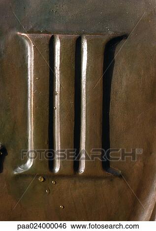 Stock Photograph - III text, embossed on bronze-colored surface. Fotosearch