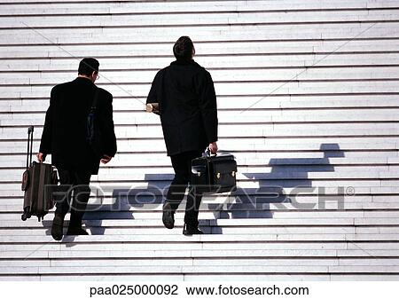 Stock Image - Businessmen walking up steps. Fotosearch