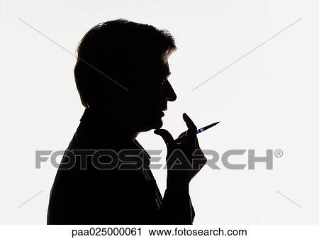 Man holding pen near mouth, silhouette. View Large Photo Image Stock Image - Man holding pen near mouth, silhouette.. Fotosearch