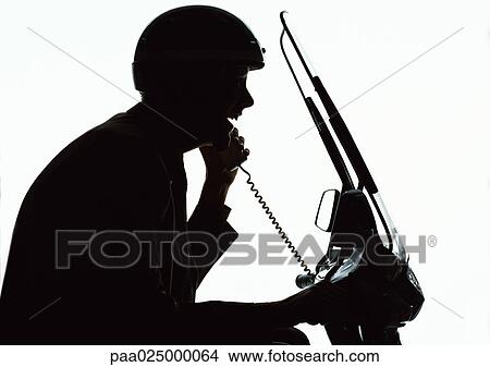 Man using phone on motorcycle, silhouette. View Large Photo Image Picture - Man using phone on motorcycle, silhouette.. Fotosearch