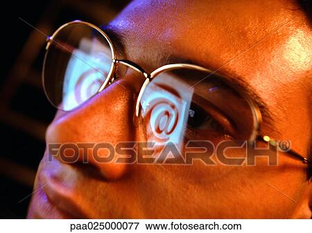 Stock Photo - Man with glasses reflecting "@".. Fotosearch