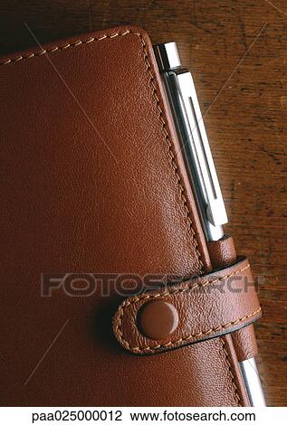 Partial view of brown leather agenda with pen, extreme close-up View Large Photo Image Stock Image - Partial view of brown leather agenda with pen, extreme close-up. Fotosearch