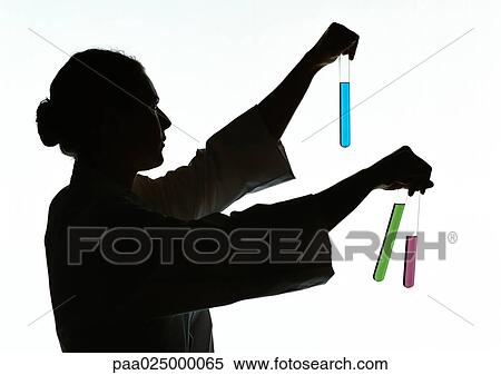 Stock Photography - Woman holding test tubes containing different colored liquids, silhouette.. Fotosearch
