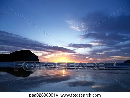New Zealand, Mahia Beach, ocean sunset with cliff in background. View Large Photo Image Picture - New Zealand, Mahia Beach, ocean sunset with cliff in background.. Fotosearch