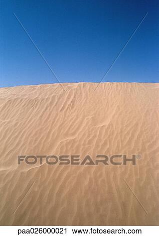 Stock Image - Tunisia, Sahara, rippled sand dune against sky.. Fotosearch