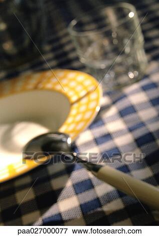 Bowl, spoon and glass on checked tablecloth, close-up, blurred View Large Photo Image Stock Photo - Bowl, spoon and glass on checked tablecloth, close-up, blurred. Fotosearch