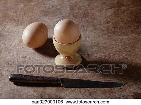 Stock Photograph - Eggs, eggcup and knife. Fotosearch