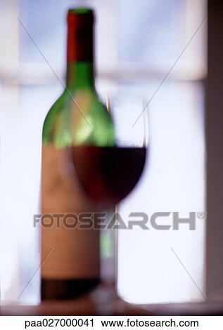 Glass of wine and wine bottle, blurred View Large Photo Image Stock Image - Glass of wine and wine bottle, blurred. Fotosearch