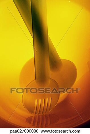 Stock Image - Salad servers in bowl, close-up. Fotosearch