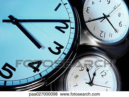 Stock Photo - Three clocks, each with hands at a different time, extreme close-up. Fotosearch
