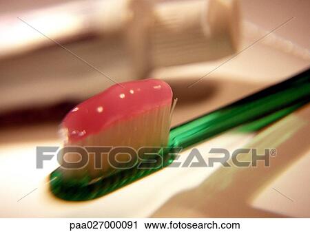 Stock Image - Toothpaste on toothbrush head, close-up. Fotosearch