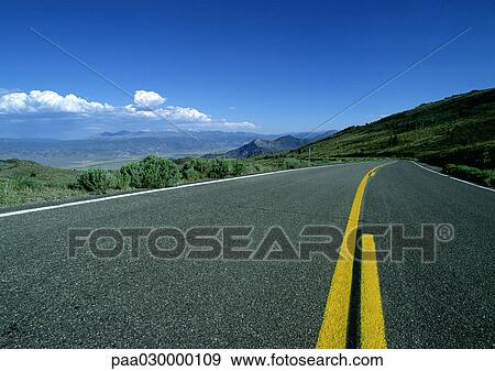 Asphalt road with yellow lines overlooking mountainous region. View Large Photo Image Stock Photo - Asphalt road with yellow lines overlooking mountainous region.. Fotosearch