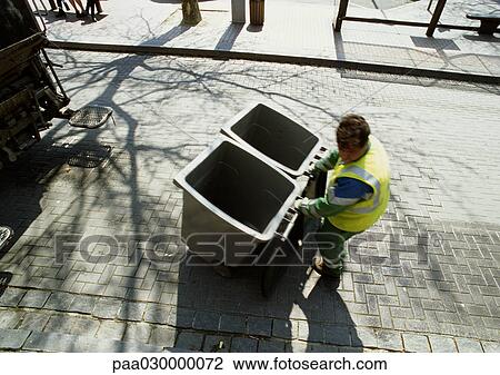 Trash collector pulling two trash cans away from dump truck. View Large Photo Image Stock Image - Trash collector pulling two trash cans away from dump truck.. Fotosearch