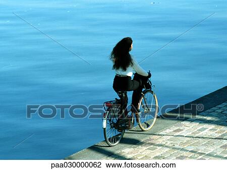 Woman riding bike near water. View Large Photo Image Stock Image - Woman riding bike near water.. Fotosearch