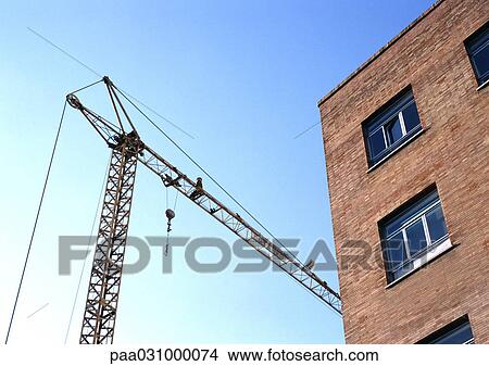 Building and crane, low angle view View Large Photo Image Picture - Building and crane, low angle view. Fotosearch
