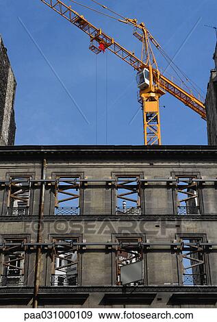 Stock Photo - Building under construction, crane in background. Fotosearch