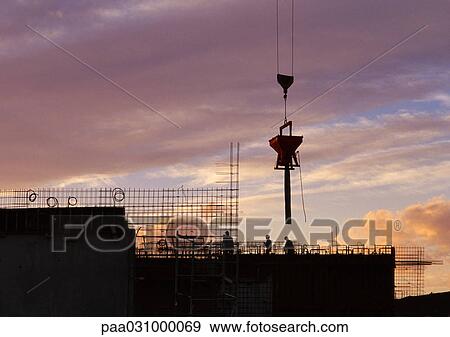 Stock Photo - Construction site, silhouette, sky at sunset in background. Fotosearch