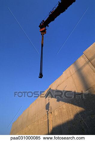 Stock Photography - Crane and shadow on wall, low angle view. Fotosearch