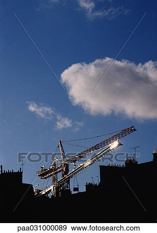 Cranes above rooftops View Large Photo Image Stock Photo - Cranes above rooftops. Fotosearch