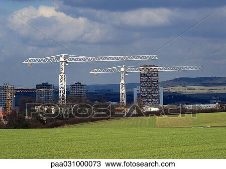 Stock Image - Lawn, cranes and high rises in background. Fotosearch