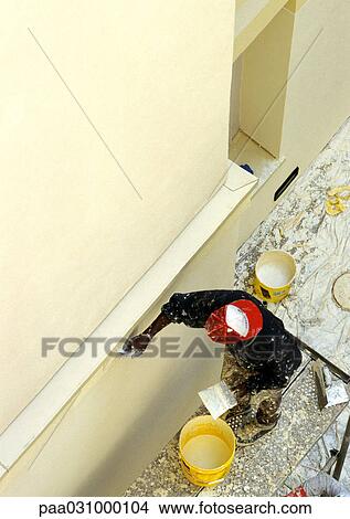 Picture - Man painting wall, elevated view. Fotosearch
