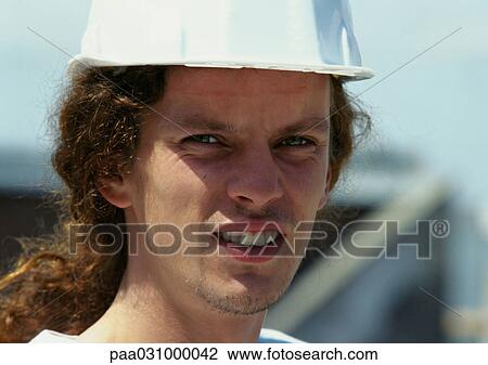 Stock Image - Man wearing hard hat, close-up. Fotosearch