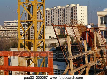 Man wearing hard hat, using cell phone in construction site View Large Photo Image Stock Photo - Man wearing hard hat, using cell phone in construction site. Fotosearch